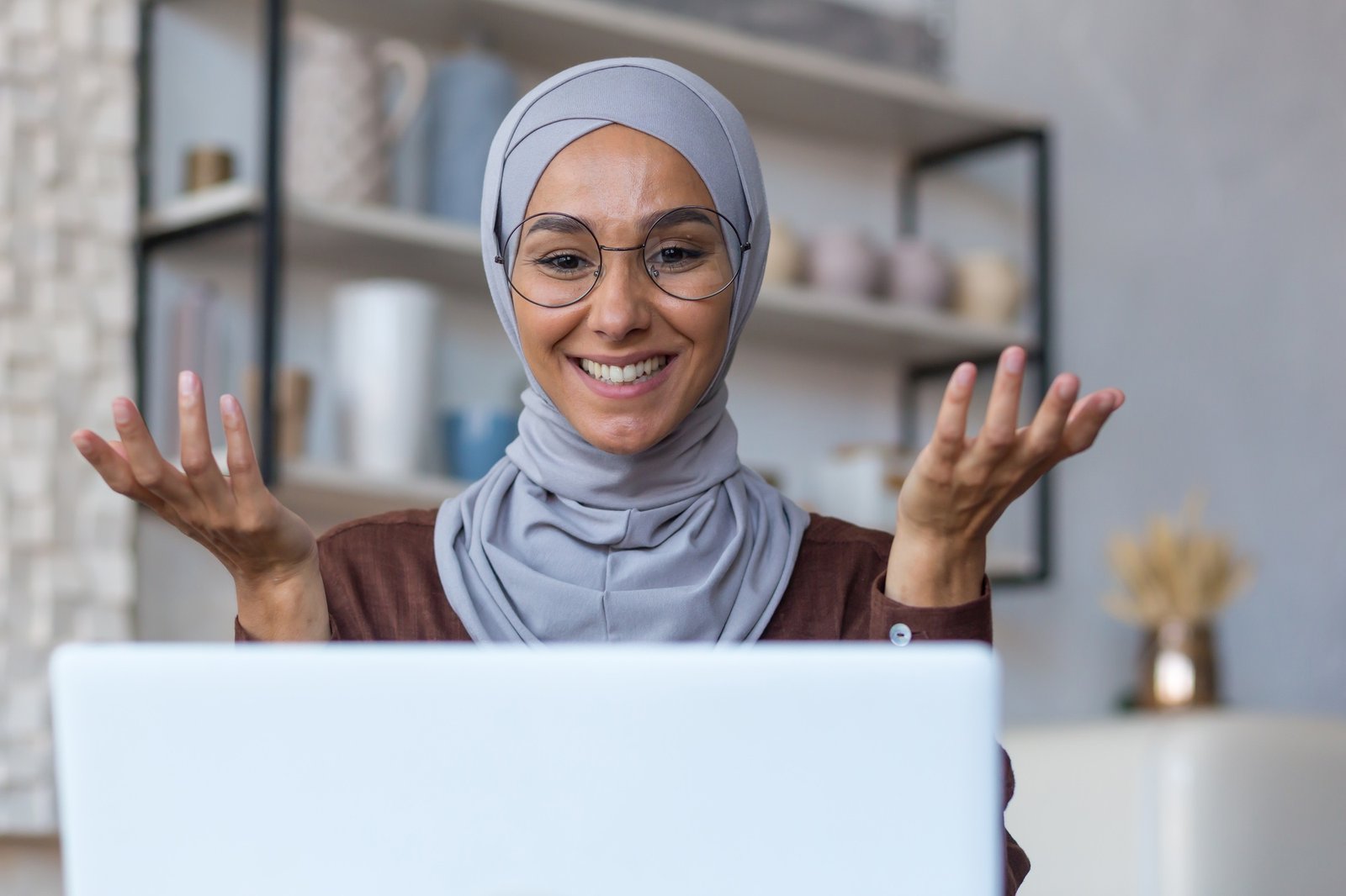 Video call online meeting with friends, young beautiful muslim woman in hijab looking at camera and